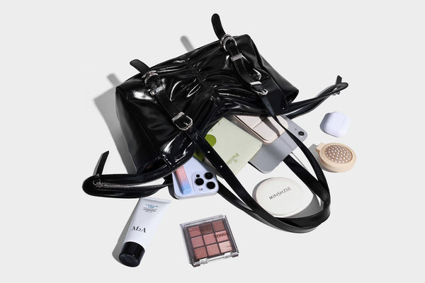 Glänzende, rechteckige Schultertasche mit Raffdetails, zwei verstellbaren Riemen, Reißverschluss oben und Schnallenbeschlägen in Silberoptik