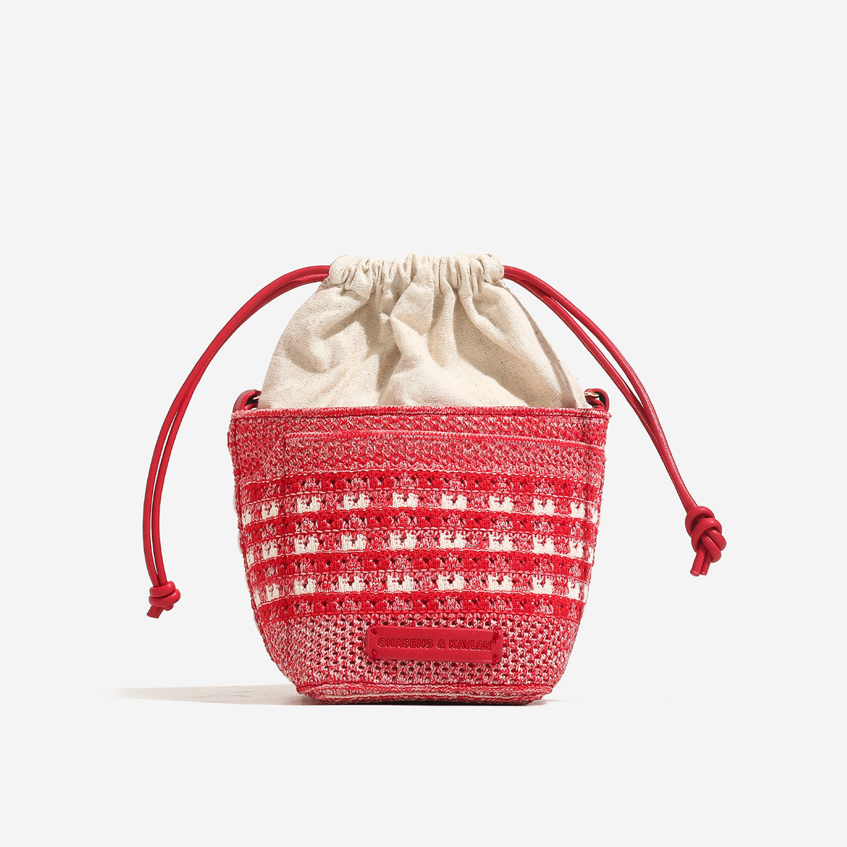 Compact openwork woven bucket bag with gathered cream drawstring liner, leather-look brown trim and cords, and gold-tone