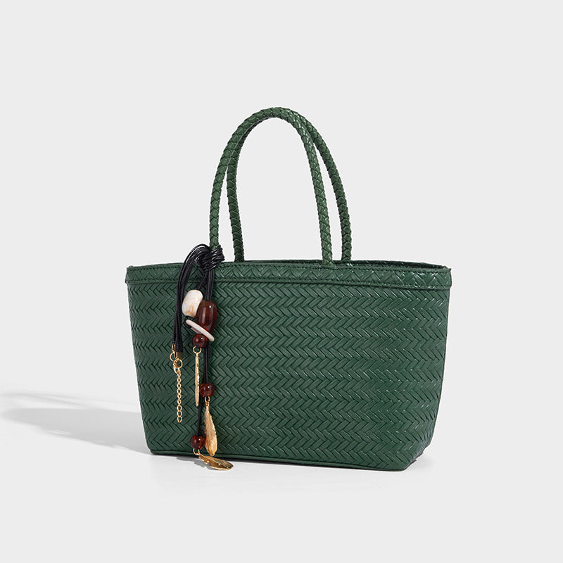 Structured chevron woven leather-look tote bag with braided top handles, gold feather charm, and adjustable shoulder strap