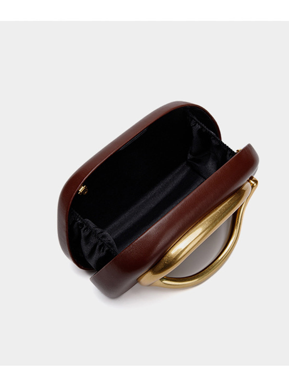Kleine Crossbody-Clutch in abgerundeter Rechteckform mit übergroßem poliertem C-förmigem Goldhenkel und schmalem Goldkettenriemen, Detailansicht