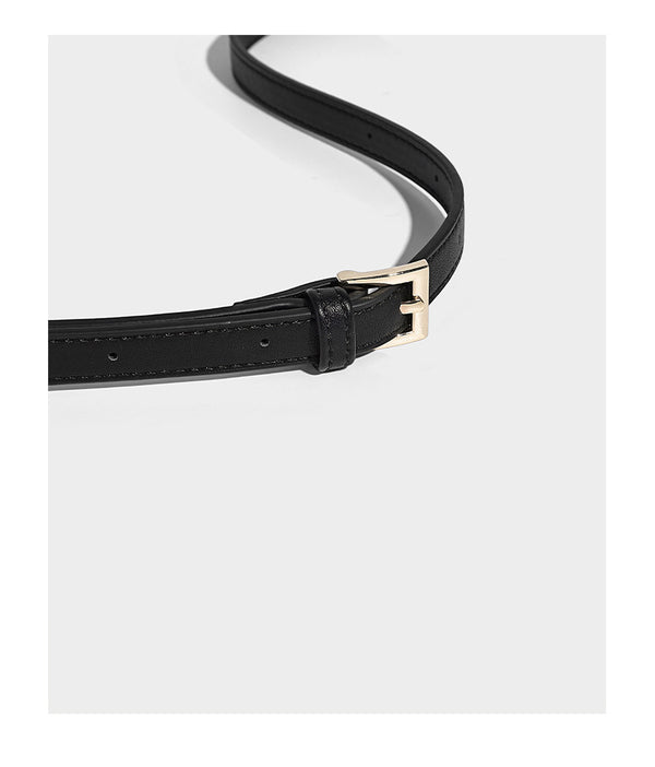 Compact bucket shoulder bag with black-and-white diamond patchwork panels, knotted top handle, gold-tone hardware, and