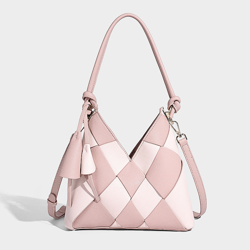 Compact bucket shoulder bag with black-and-white diamond patchwork panels, knotted top handle, gold-tone hardware, and