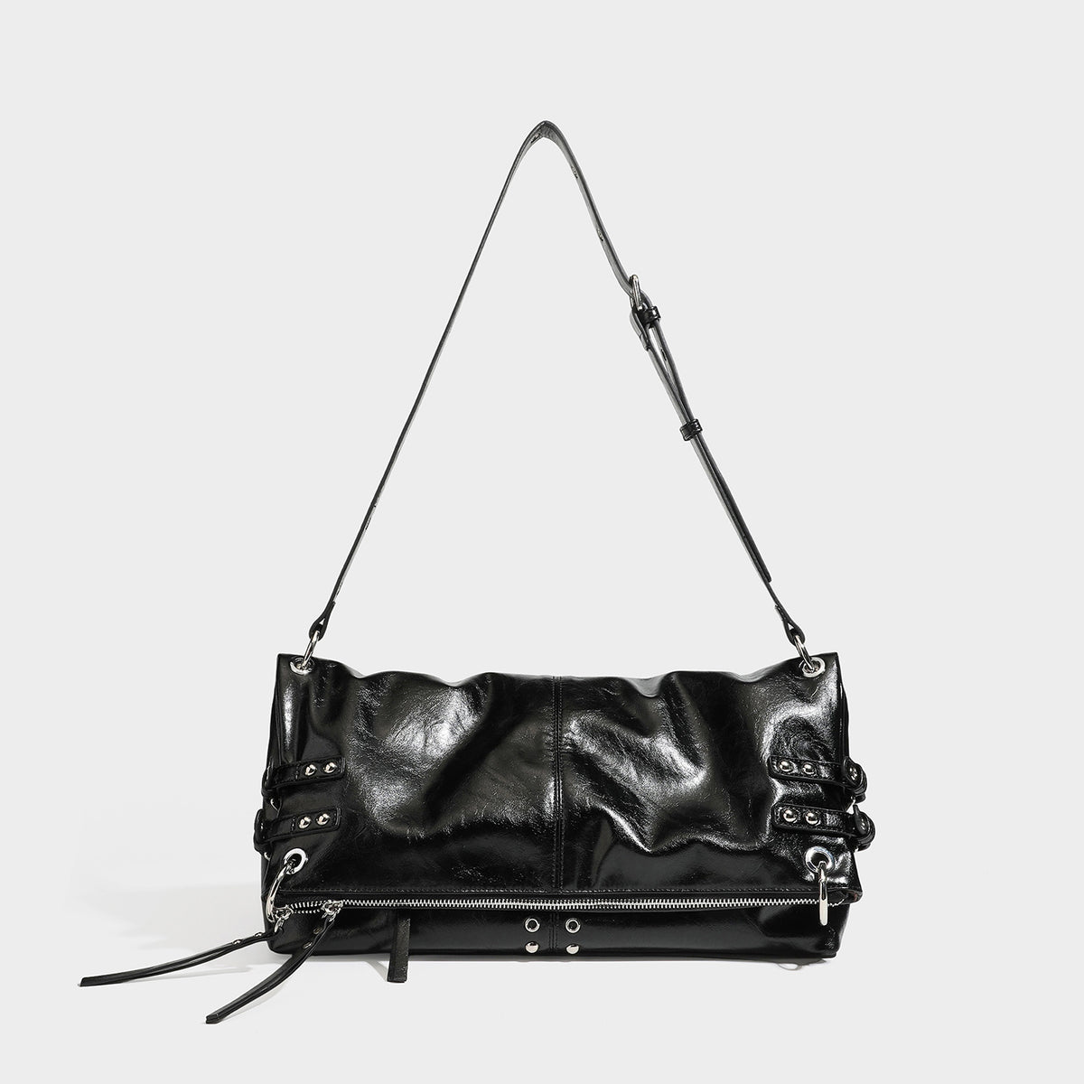 Black glossy leather-look slouchy shoulder bag with silver stud and eyelet hardware, top zip closure, front zip pocket, and
