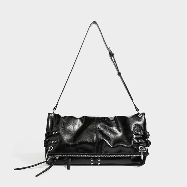 Black glossy leather-look slouchy shoulder bag with silver stud and eyelet hardware, top zip closure, front zip pocket, and