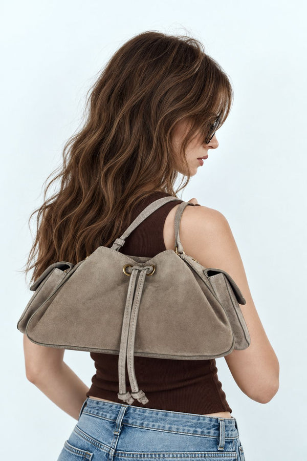 Weiche Beuteltasche in Taupe in Velourslederoptik mit seitlichen Taschen mit Überschlag, Beschlägen in Antikgoldoptik und verstellbarem Crossbody-Riemen
