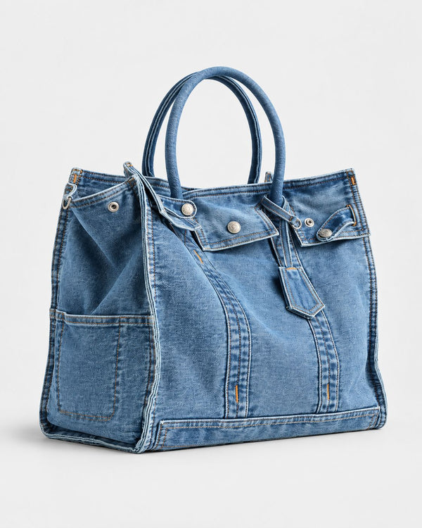Large washed denim patchwork tote bag with snap-flap front pockets, rolled handles, and detachable shoulder strap, detail
