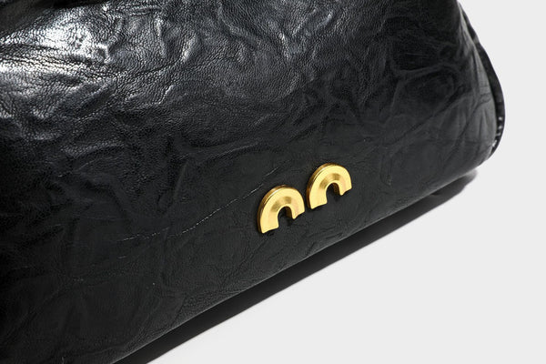 Compact black crinkled leather-look baguette shoulder bag with gold-tone arch hardware and adjustable strap, detail view 29
