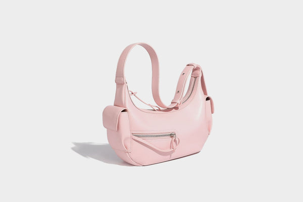 Smooth leather-look crescent shoulder bag with front zip pocket, side flap pockets, adjustable strap, and silver-tone, detail