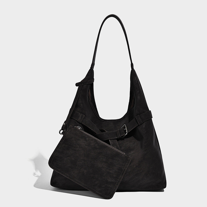 Slouchy oversized shoulder tote bag with matte textured finish, wrap-around buckle strap, and detachable front zip pouch