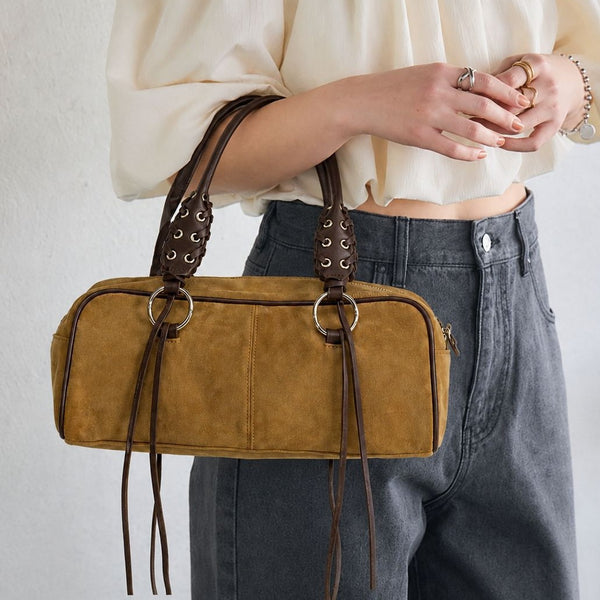 Rectangular suede-look barrel bag with laced eyelet handles, silver O-ring hardware, and hanging leather-look fringe tie