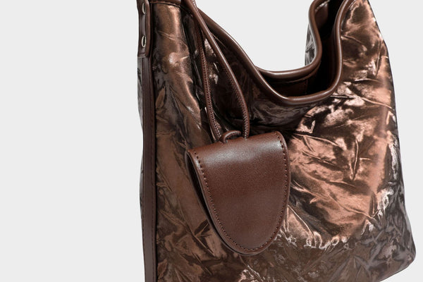 Große Hobo-Schultertasche mit Crinkle-Glanzfinish in Dunkelbraun, schmalem verstellbarem Riemen, geknoteten Beschlägen und seitlich befestigter Klappe