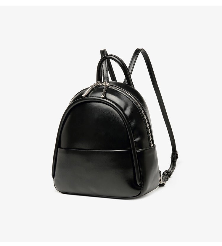Kleine kuppelförmige Mini-Rucksackhandtasche in Pastellgelb mit glatter Lederoptik, oberem Bogenreißverschluss und silberfarbenen Details, Detailansicht
