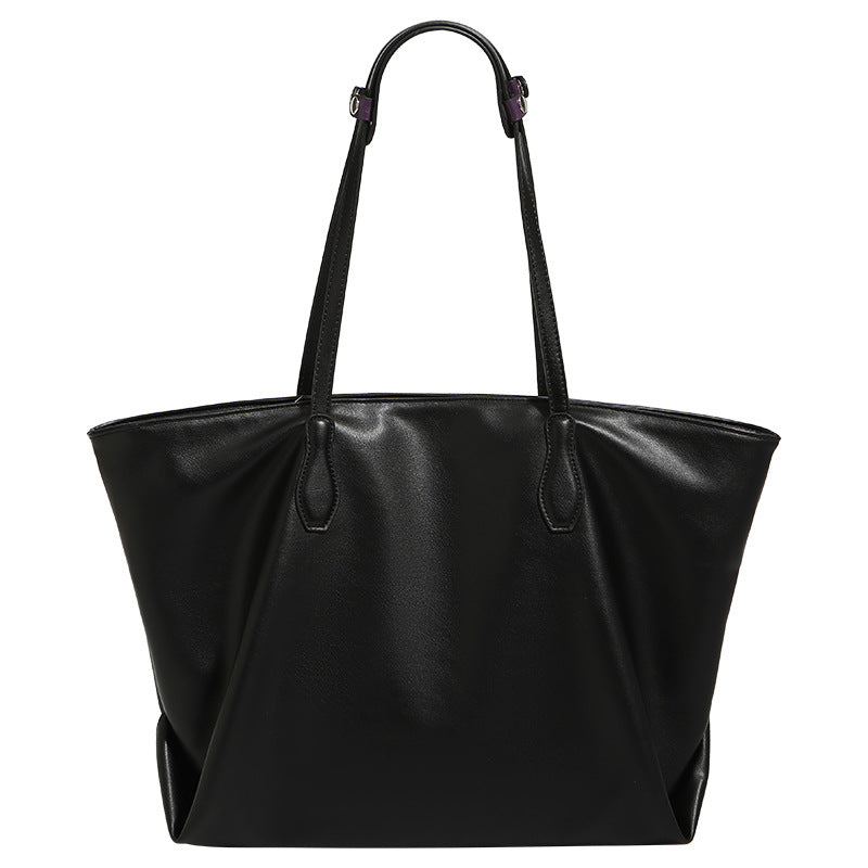 Large black leather-look trapezoid tote bag with double shoulder straps and purple accent hardware, detail view 5