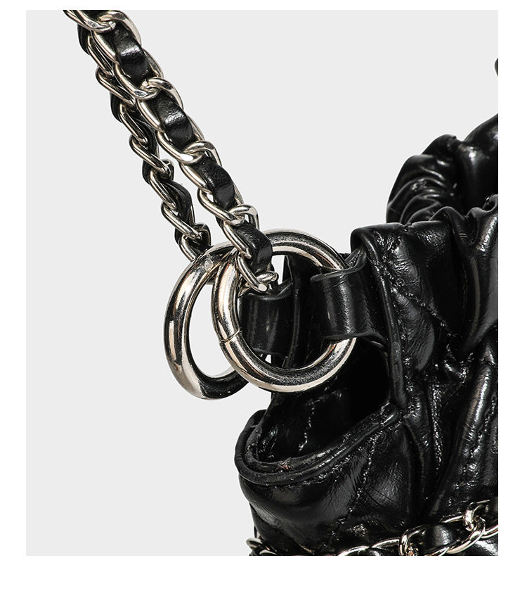 Glossy diamond-quilted drawstring bucket bag with silver chain shoulder strap and medallion charm, detail view 19
