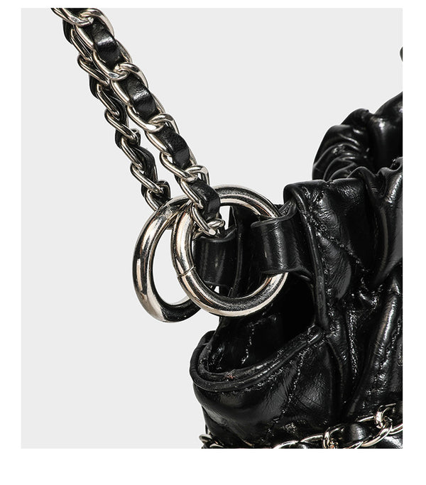Glossy diamond-quilted drawstring bucket bag with silver chain shoulder strap and medallion charm, detail view 19