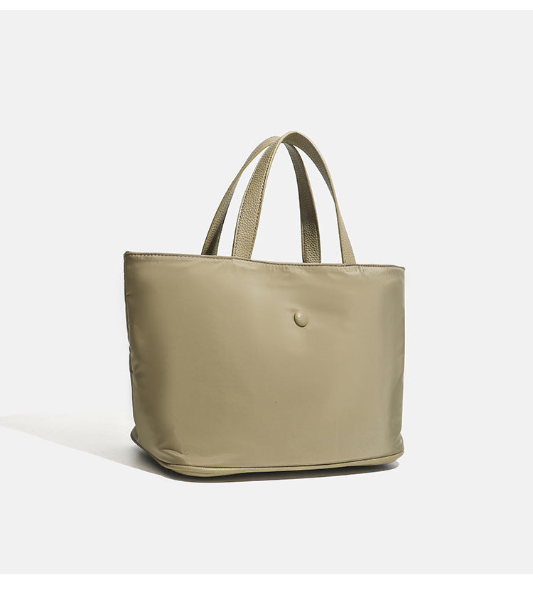 Structured lightweight nylon tote bag with textured double top handles and snap-button front detail, detail view 16
