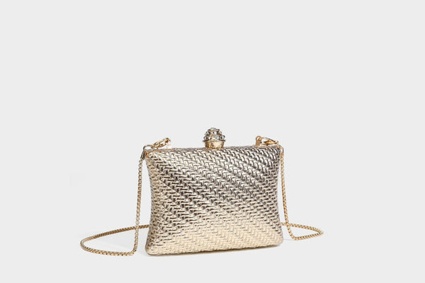 Small structured rectangular metallic woven-texture clutch bag with jeweled knob clasp and gold-tone chain strap, detail view