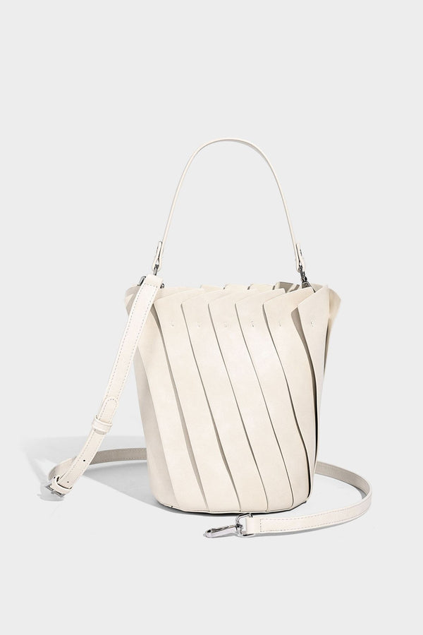 Structured pleated-panel bucket bag with curved top handle and detachable adjustable shoulder strap in smooth matte, detail