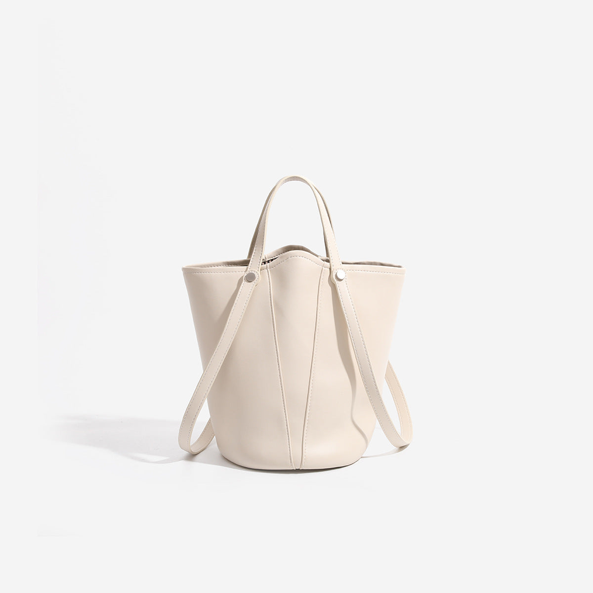 Large leather-look bucket tote bag with dual top handles and adjustable crossbody strap, detail view 7