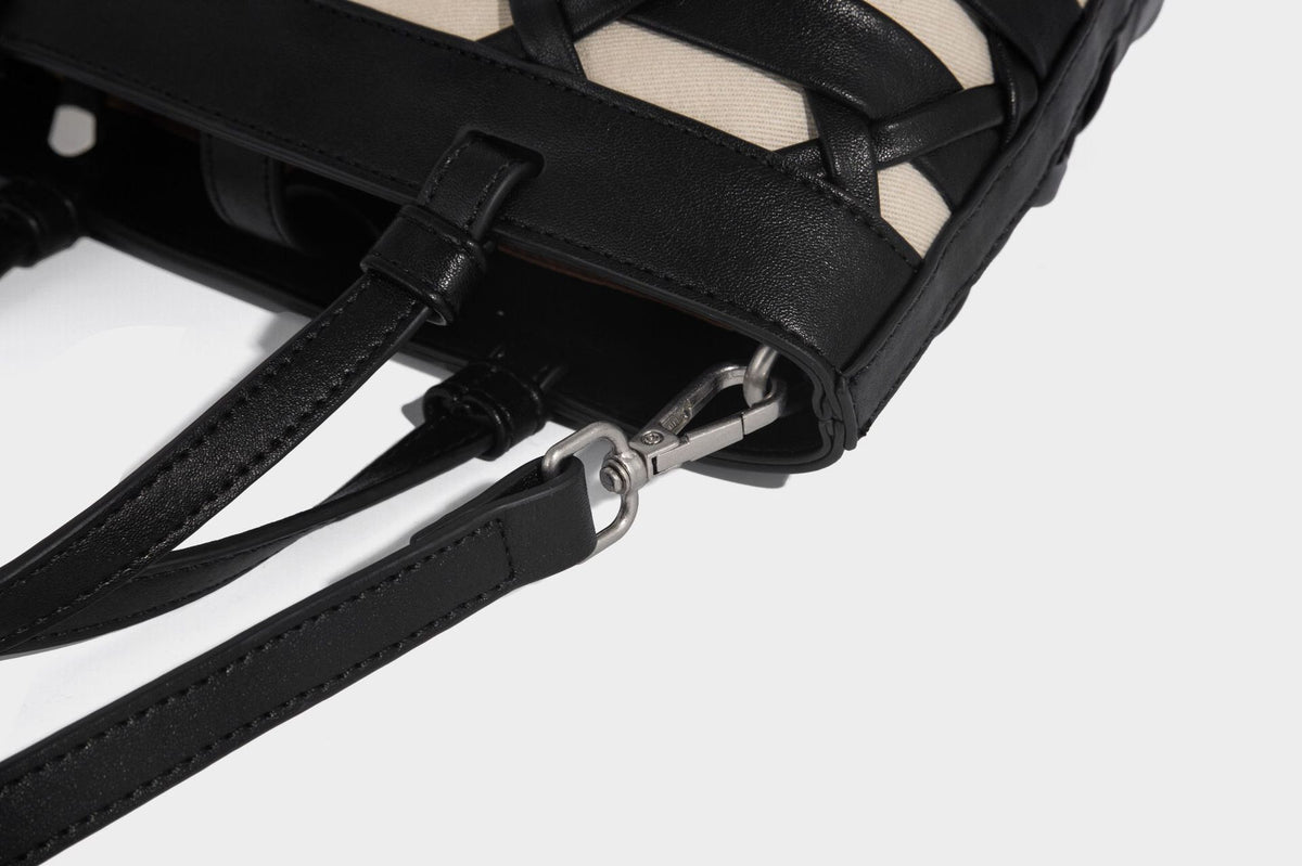 Structured woven lattice tote bag with cream lining, dual top handles, detachable crossbody strap, and silver-tone hardware