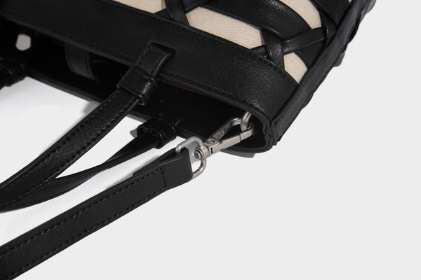 Structured woven lattice tote bag with cream lining, dual top handles, detachable crossbody strap, and silver-tone hardware