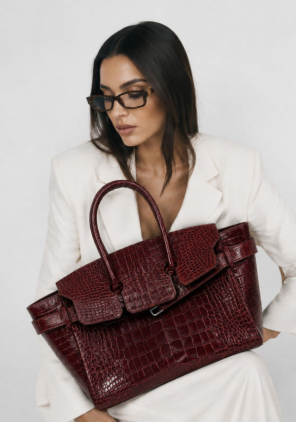 Large structured tote satchel with glossy crocodile-embossed leather-look finish, dual top handles, and metal buckle flap