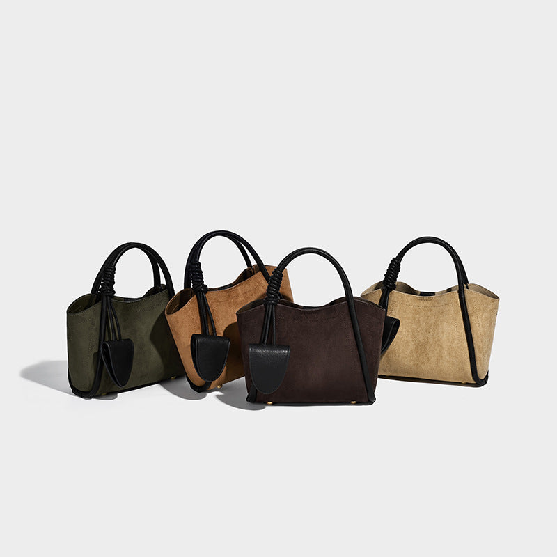Small structured open-top tote bag in dark brown matte suede-like finish with black knotted top handles, attached front