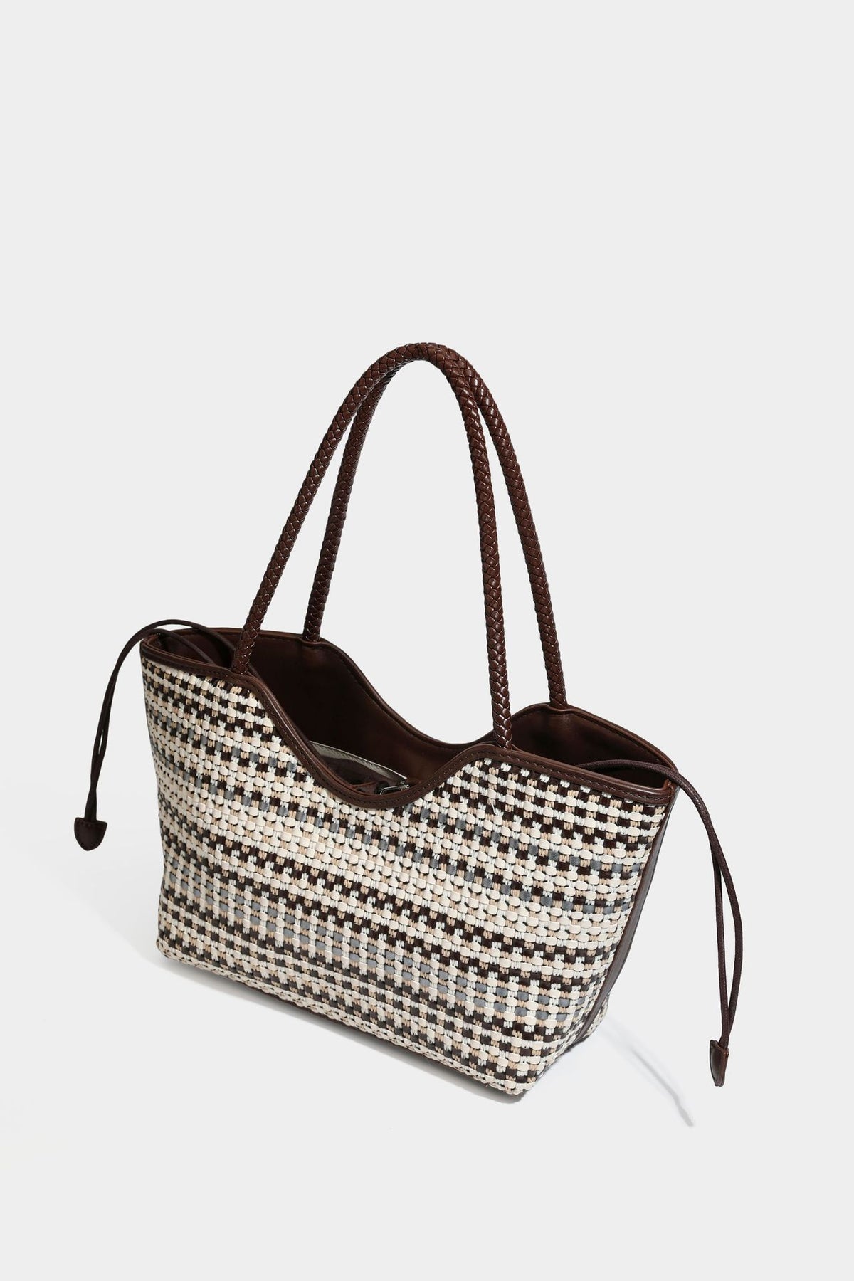 Large woven checker-pattern tote bag with dark braided shoulder straps, leather-look trim, and drawstring side ties, detail