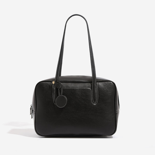Structured boxy bowling-style tote bag in deep brown leather-look finish with dual top handles, front slip pocket, round