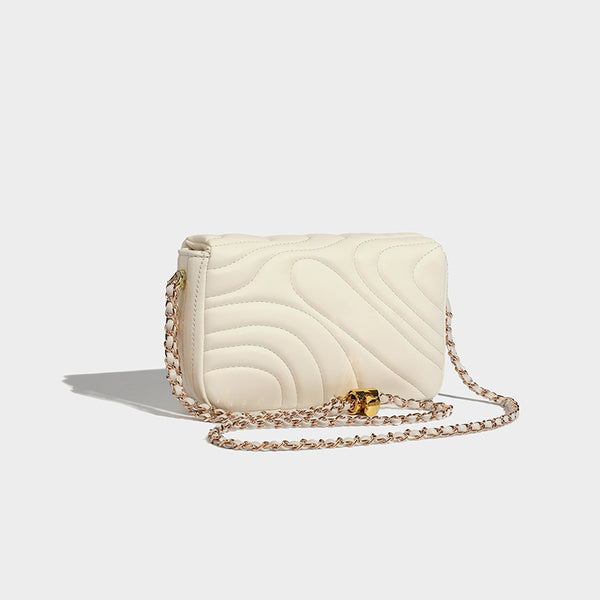 Compact cream quilted flap crossbody bag with wave stitching, gold-tone chain strap, and four-petal turn-lock clasp, detail