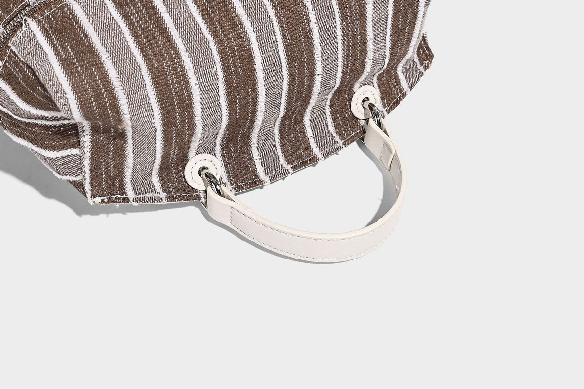 Small structured striped fabric backpack handbag with cream leather-look trim, top handle, and silver-tone hardware, detail