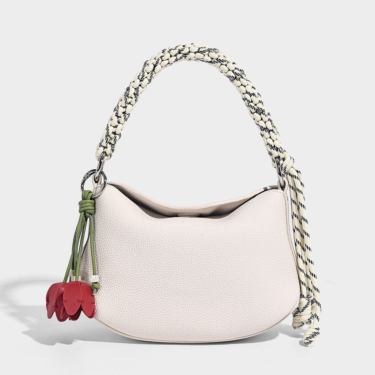 Small crescent half-moon bag in pebbled leather-look finish with braided top handle, silver-tone ring hardware, and, detail