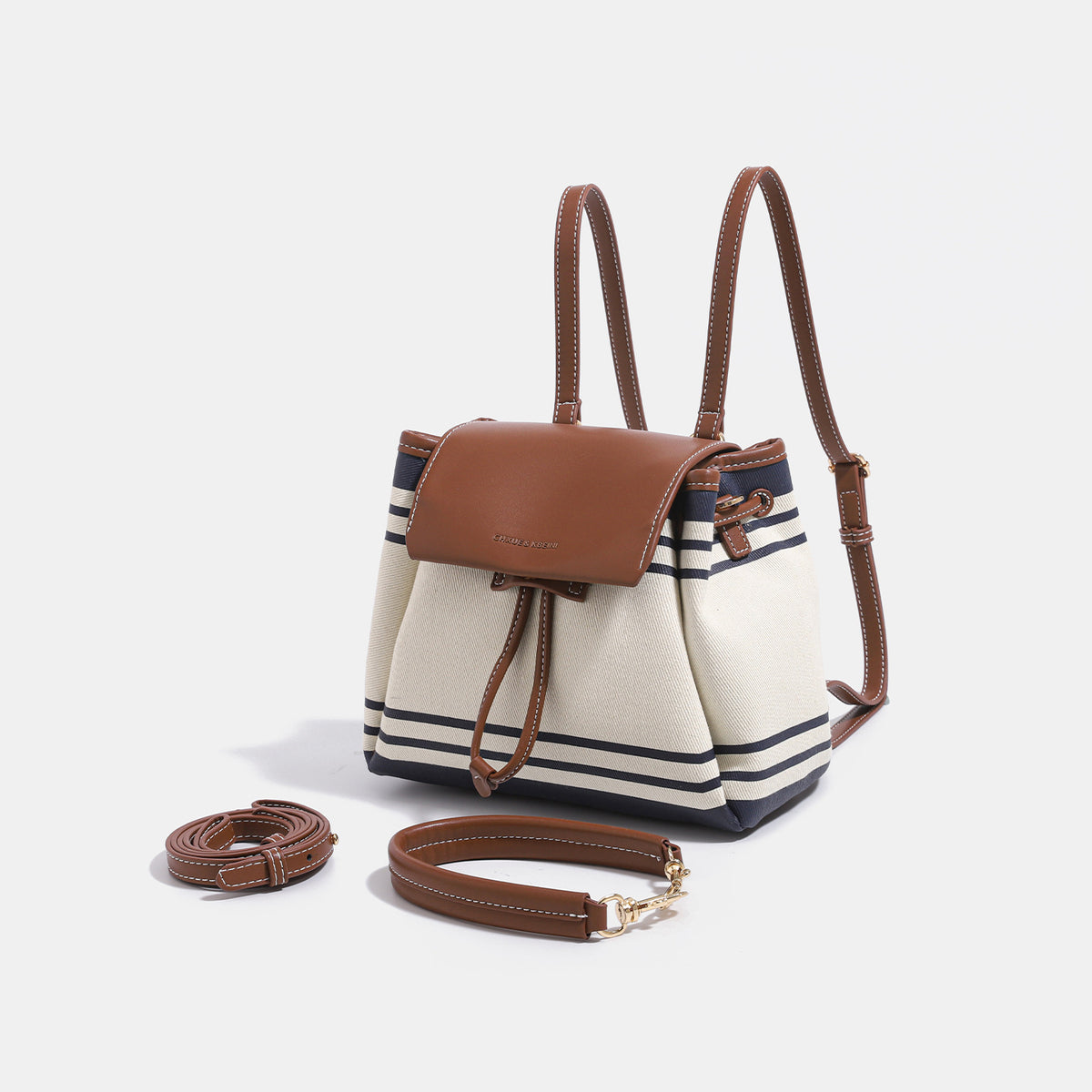 Cremefarbene Canvas-Beuteltasche mit marineblauen horizontalen Streifen, cognacfarbenem Kunstleder-Lappen und -Besatz, goldfarbenen Metalldetails und wandelbarer Trageweise