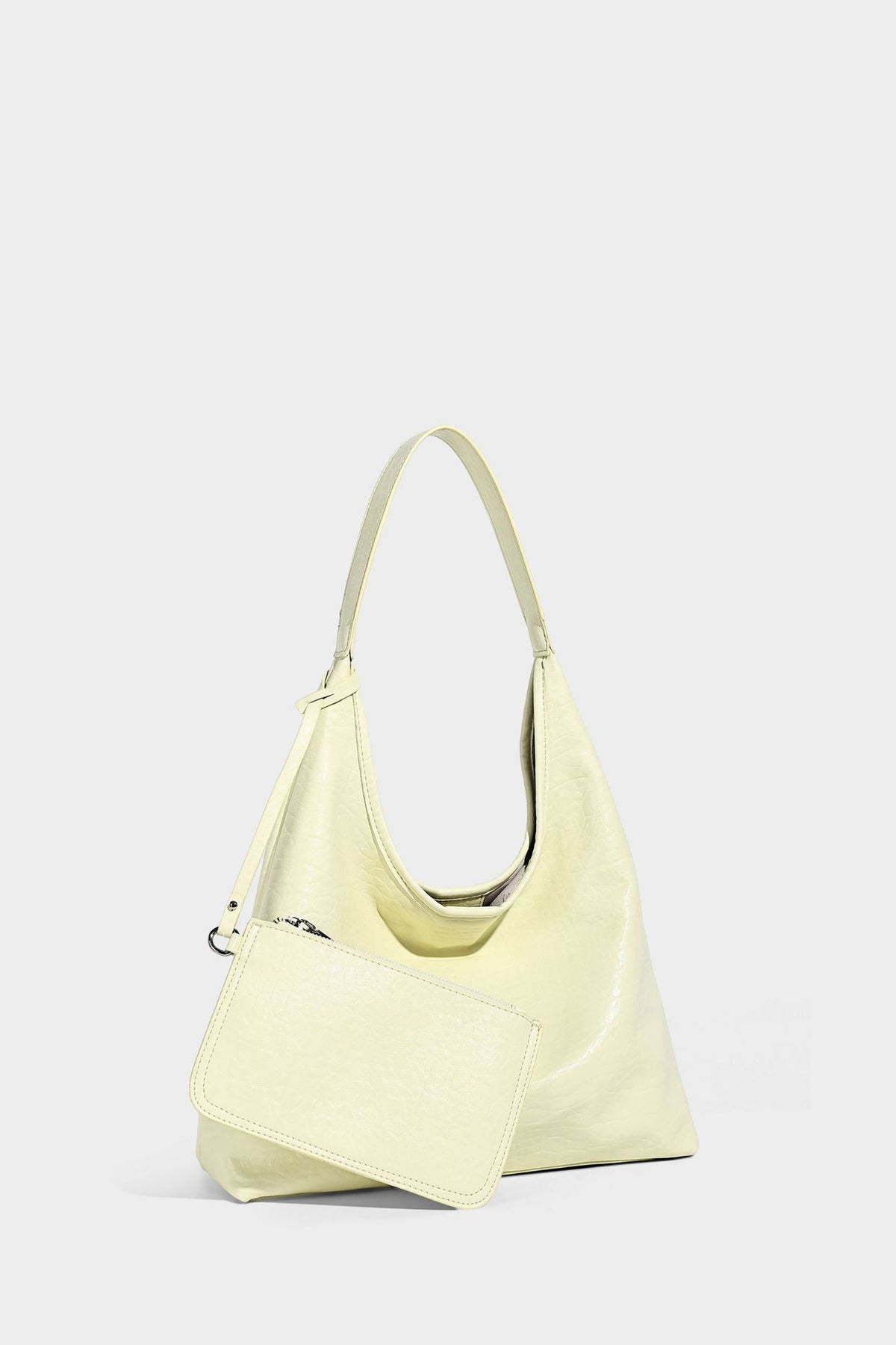 Slouchy hobo shoulder bag in pale yellow glossy pebbled leather-look finish with single shoulder strap and detachable front