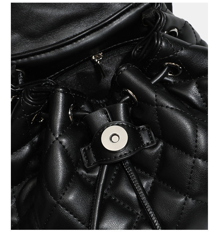 Black diamond-quilted backpack handbag with silver-tone chain flap accent and adjustable shoulder straps, detail view 19