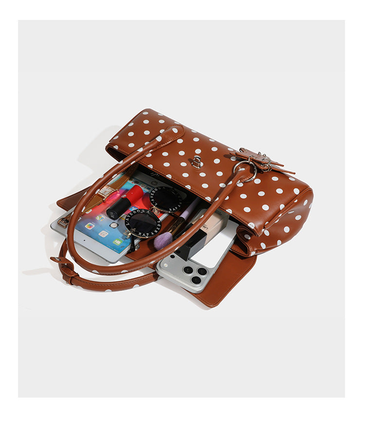 Strukturierte Baguette-Tasche mit Polka-Dot-Muster, glänzender Lederoptik, zwei Tragegriffen, silberfarbener Drehverschlussklappe und