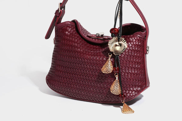 Small woven-look leather-look flap shoulder hobo bag in burgundy with silver-tone hardware and decorative tassel charm