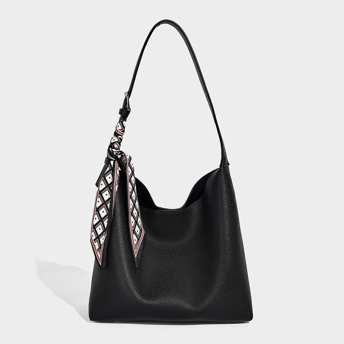 Soft slouchy hobo shoulder bag in pebbled matte finish with slim strap, silver-tone ring hardware, and knotted printed scarf