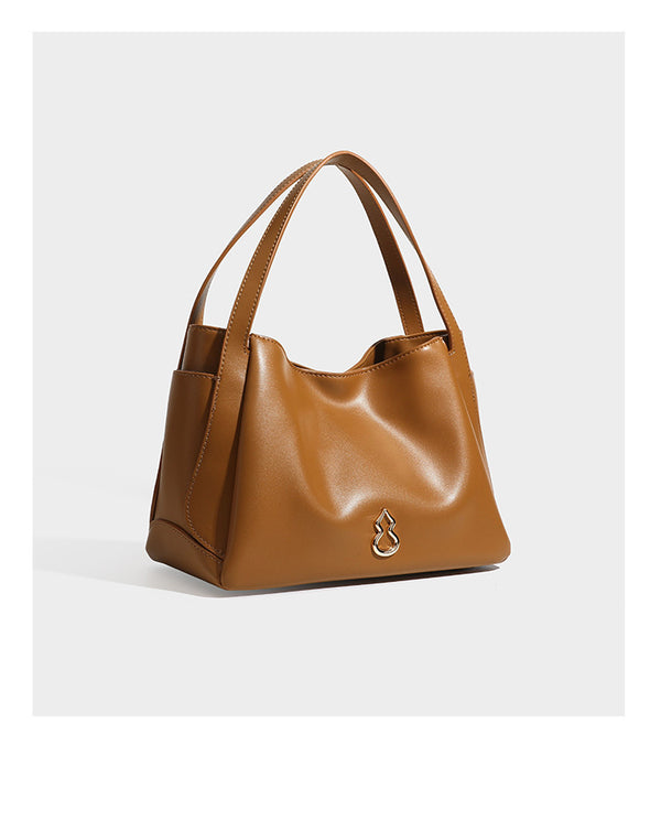 Structured glossy leather-look tote shoulder bag with dual top handles, detachable crossbody strap, side pockets, and, detail