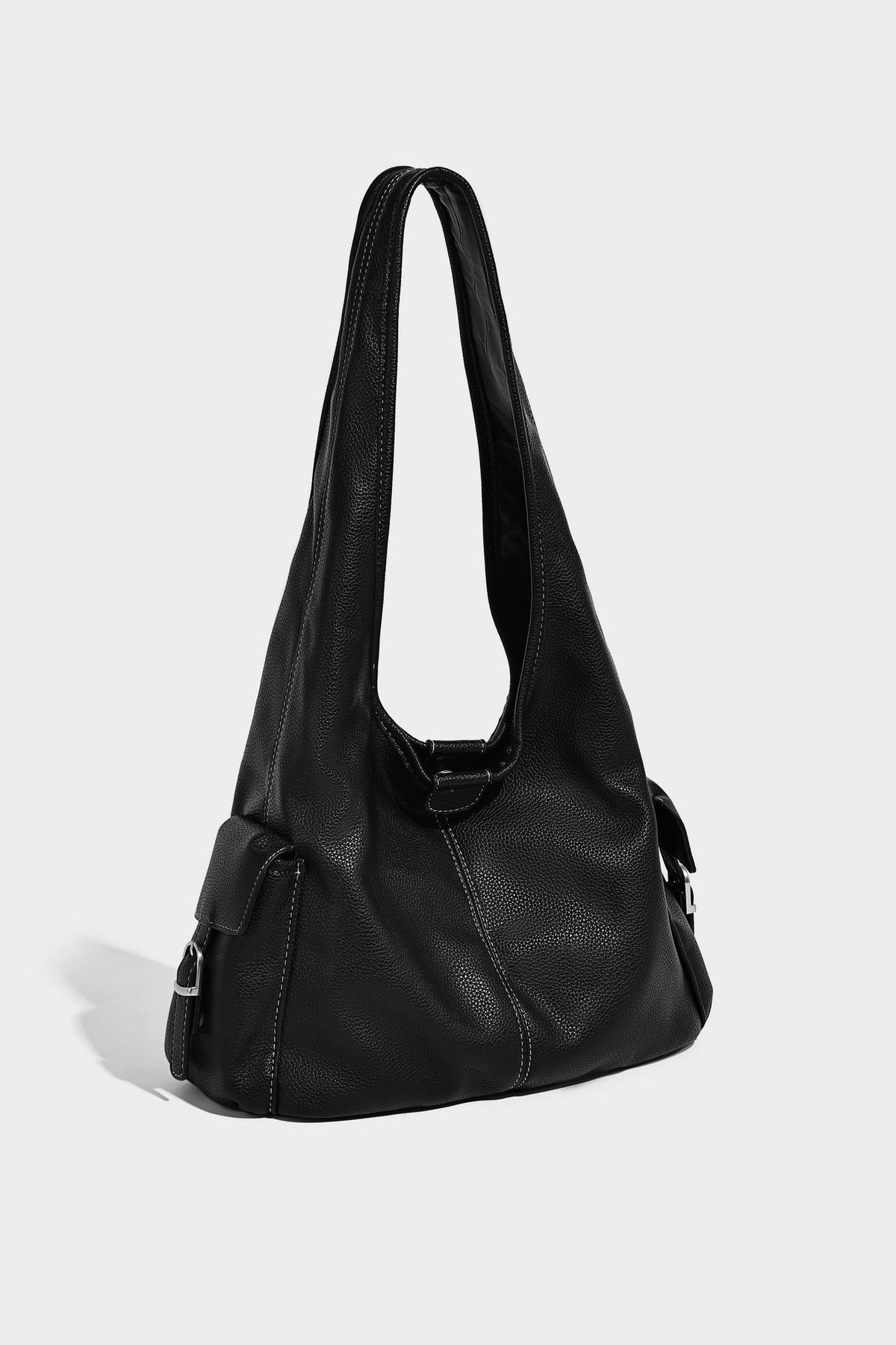 Große, lässig drapierte Hobo-Schultertasche in genarbter Lederoptik mit langem Schulterriemen und seitlicher Klappentasche mit Beschlägen, Detailansicht