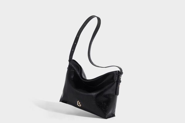 Large slouchy hobo shoulder bag in glossy crinkle leather-look finish with gold-tone emblem hardware and adjustable strap