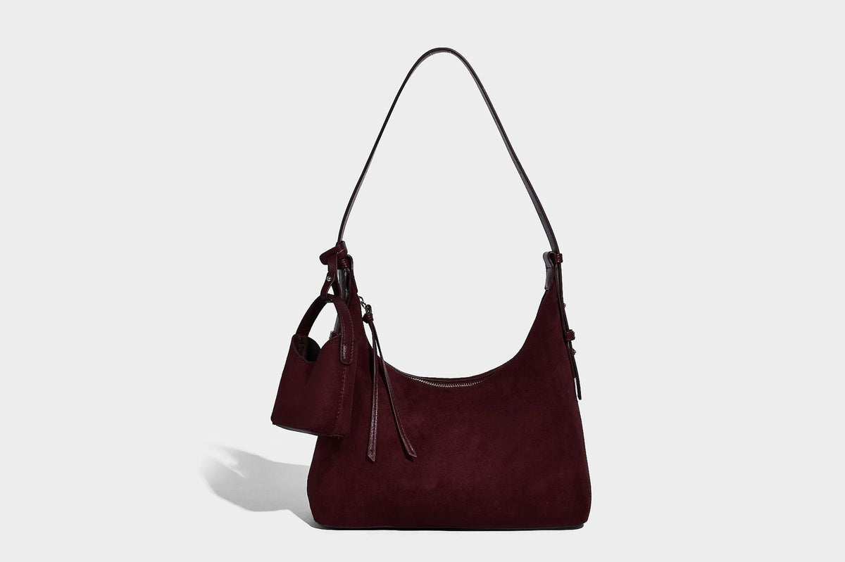 Dark brown suede-look hobo shoulder bag with top zip closure, adjustable strap, and small detachable mini pouch, detail view