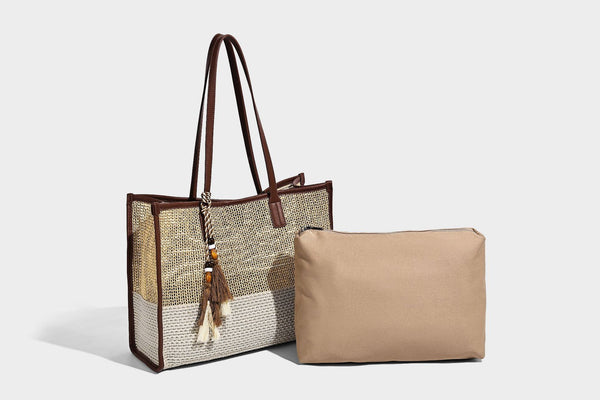 Große Tote-Bag aus grob geflochtenem Stroh in Beige und Creme mit dunkelbraunen Details in Lederoptik, langen Schulterriemen und einem mit Perlen verzierten