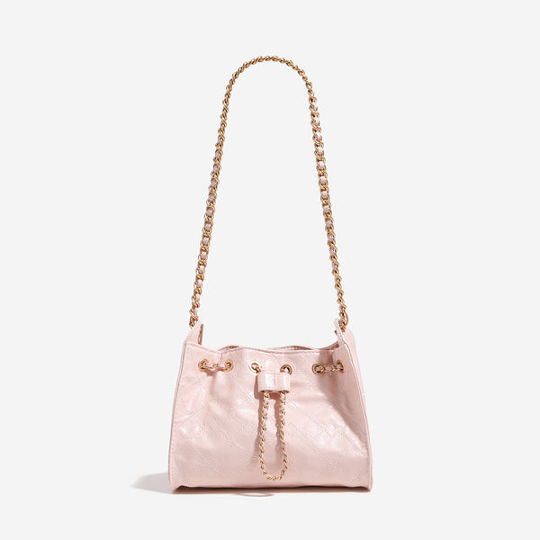 Glossy diamond-quilted drawstring bucket bag with gold-tone chain strap and eyelet hardware, front view