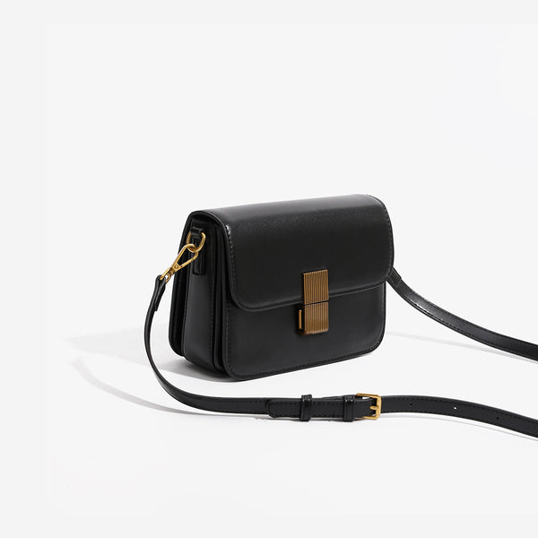 Mini structured black flap crossbody bag with gold-tone ribbed rectangular clasp and adjustable shoulder strap, detail view 3
