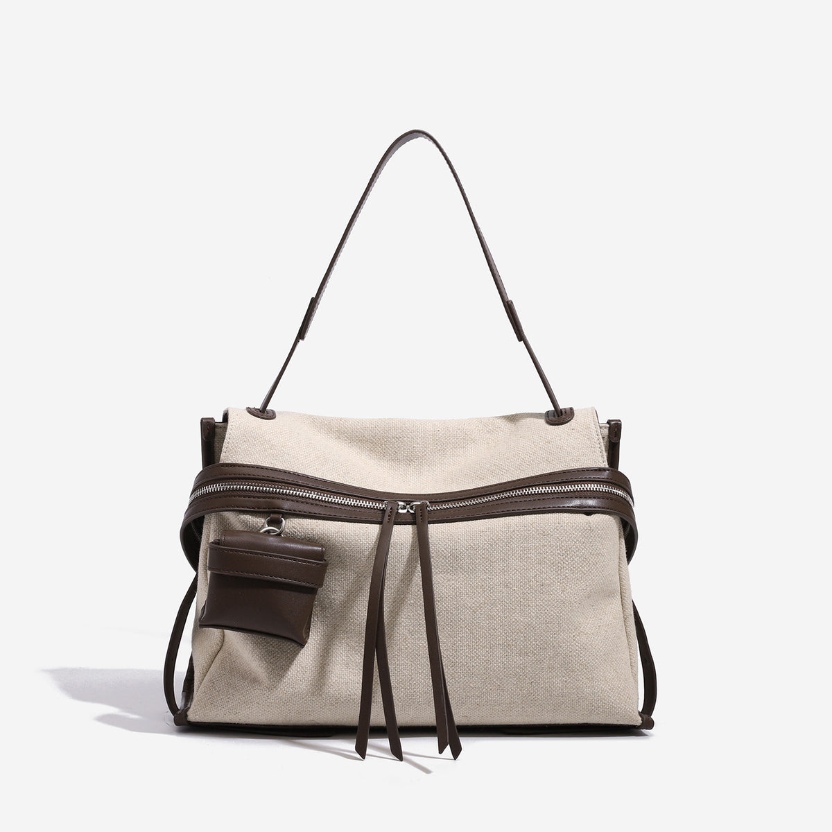 Cream canvas messenger shoulder bag with tan leather-look trim, dual zippers, tassel pulls, and attached mini front pouch