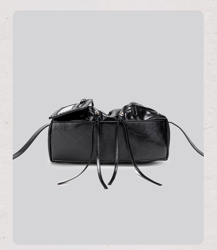 Black glossy ruched convertible tote bag with silver-tone rivets, detachable wide shoulder strap, external zip pouch, and