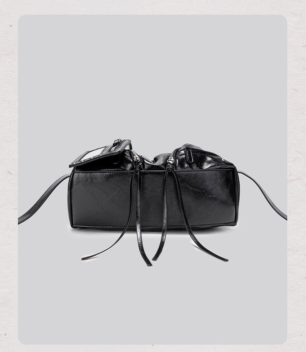 Black glossy ruched convertible tote bag with silver-tone rivets, detachable wide shoulder strap, external zip pouch, and