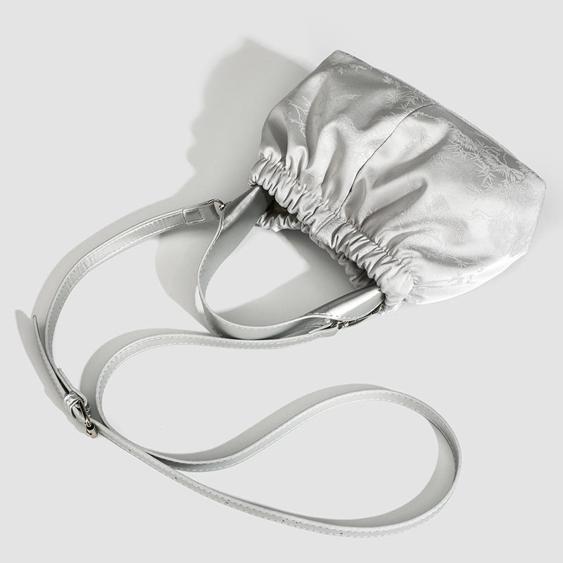 Small ruched satin-finish cloud bag with elasticized drawstring top, short top handle, and chunky silver-tone chain strap