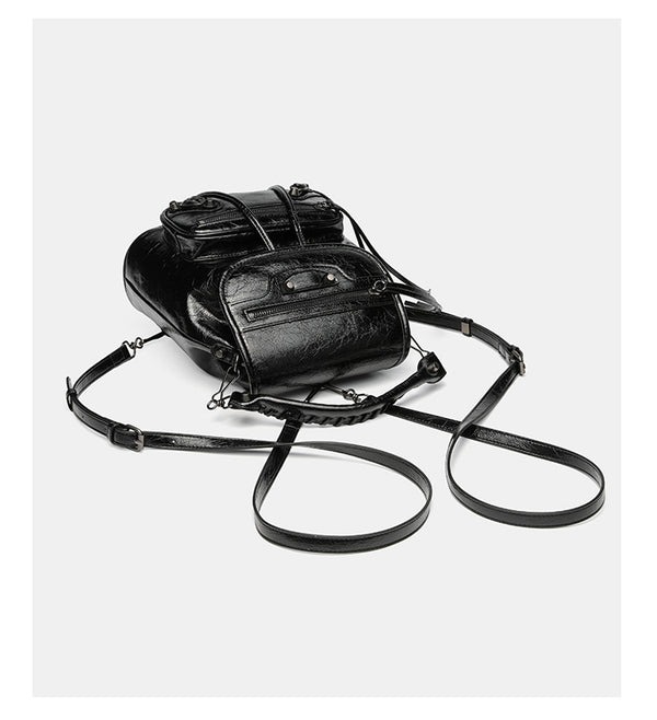 Small structured glossy leather-look convertible backpack handbag in black with flap closure, front zip pockets, metal stud